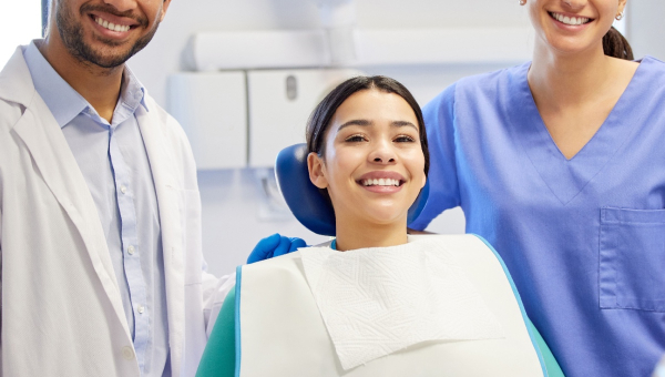 A happy dentist with his patient and assistant